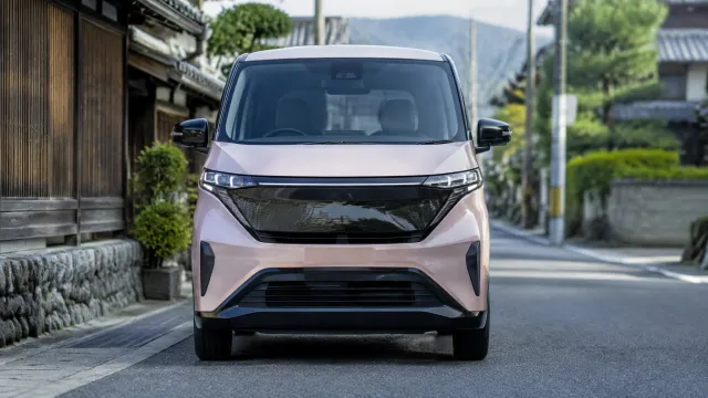 A small electric Nissan Sakura kei car, one of the models on Japan's subsidy list, photographed from the front on a Japanese street. AI-generated illustration.
