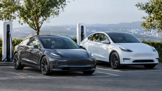 A Tesla Model 3 and a Model Y standing at a charging bay, the two Shanghai-built models that South Korea has not certified for Full Self-Driving. AI-generated illustration.